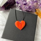 Orange and pink striped statement heart necklace made from polymer clay.