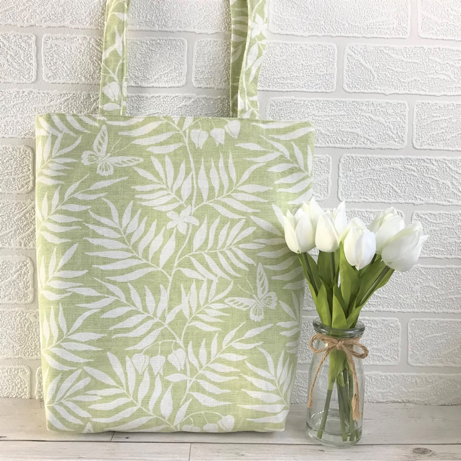 Pale green tote bag with white leaves, butterflies and flowers print
