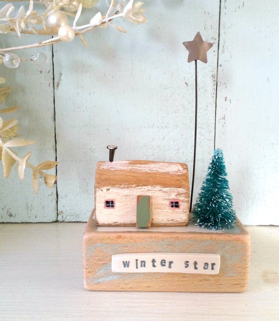 Little wooden house with Christmas tree and star