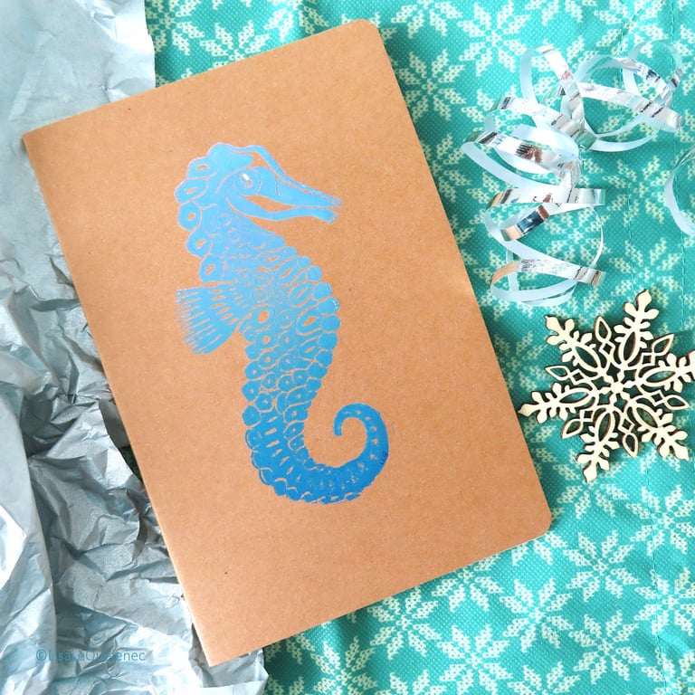 Hand printed lino seahorse motif A5 notebook in blue ink on a brown kraft cover
