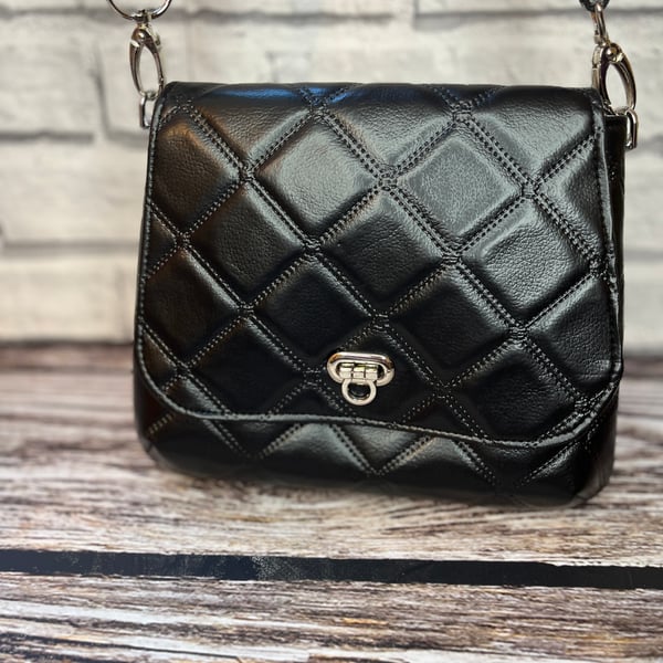 Black quilted crossbody bag with webbing adjustable strap