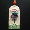 Ceramic tag decoration with bird and flower button