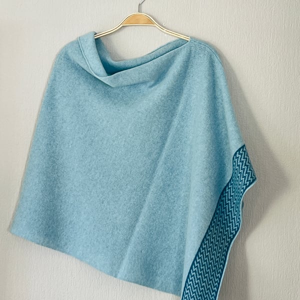 Poncho soft merino lambswool light blue with zigzag petrol blue border