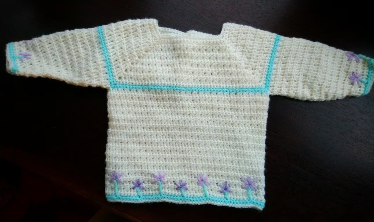 Crochet Baby jumper in cream with mauve embroidered flowers 22 in chest. 