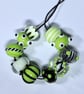 Handmade green, black and white lamp work glass beads