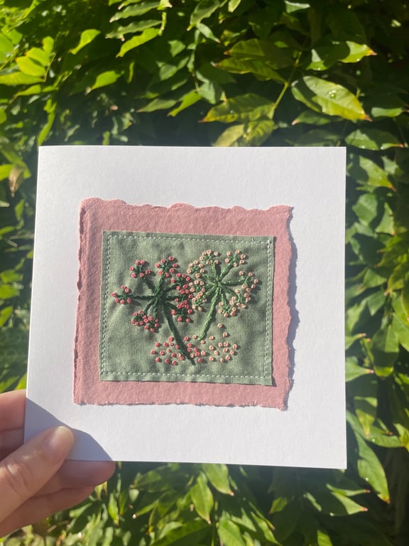 Hand embroidered flowers on dark green fabric