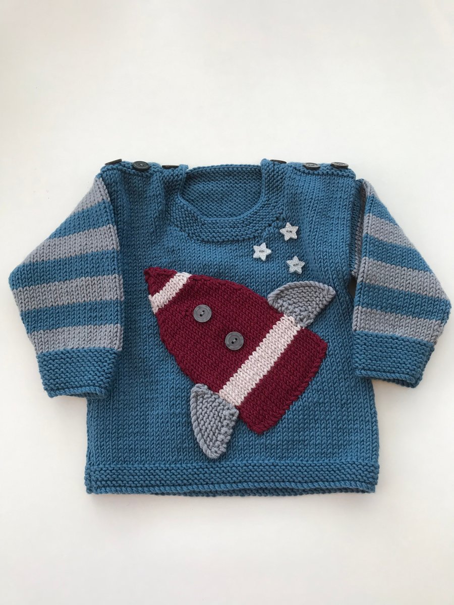 Hand knitted baby jumper with a rocket design 
