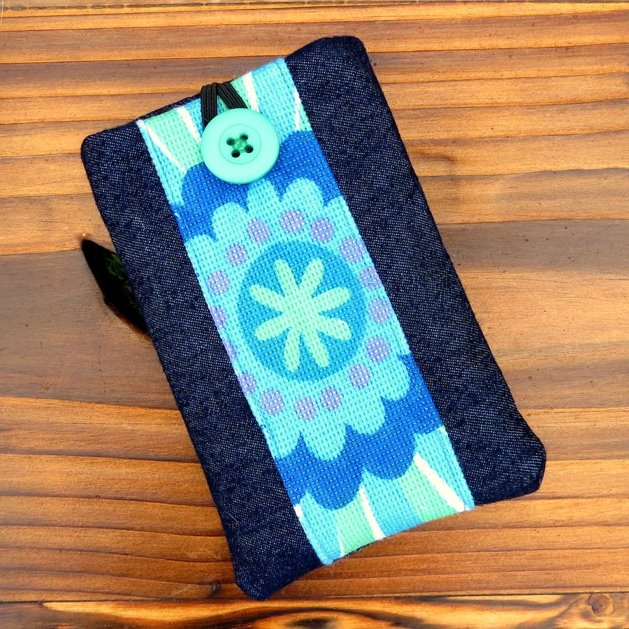 A mobile sleeve,  iphone sleeve.  1970s flower power and denim.