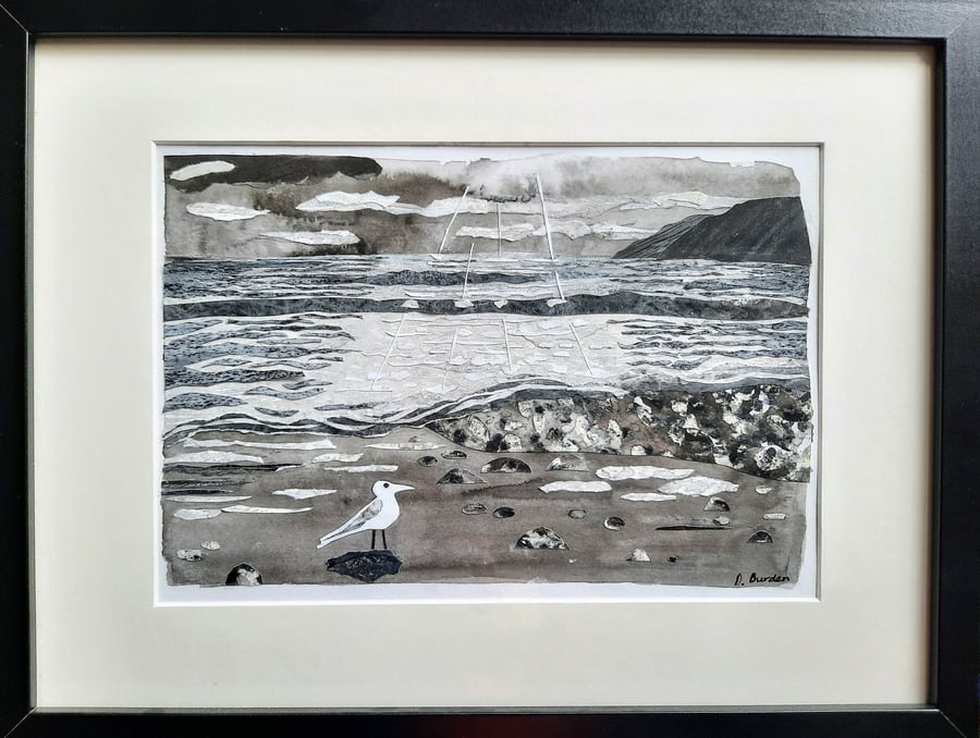 "Breaking through the clouds". Framed coastal collage in black and white. 