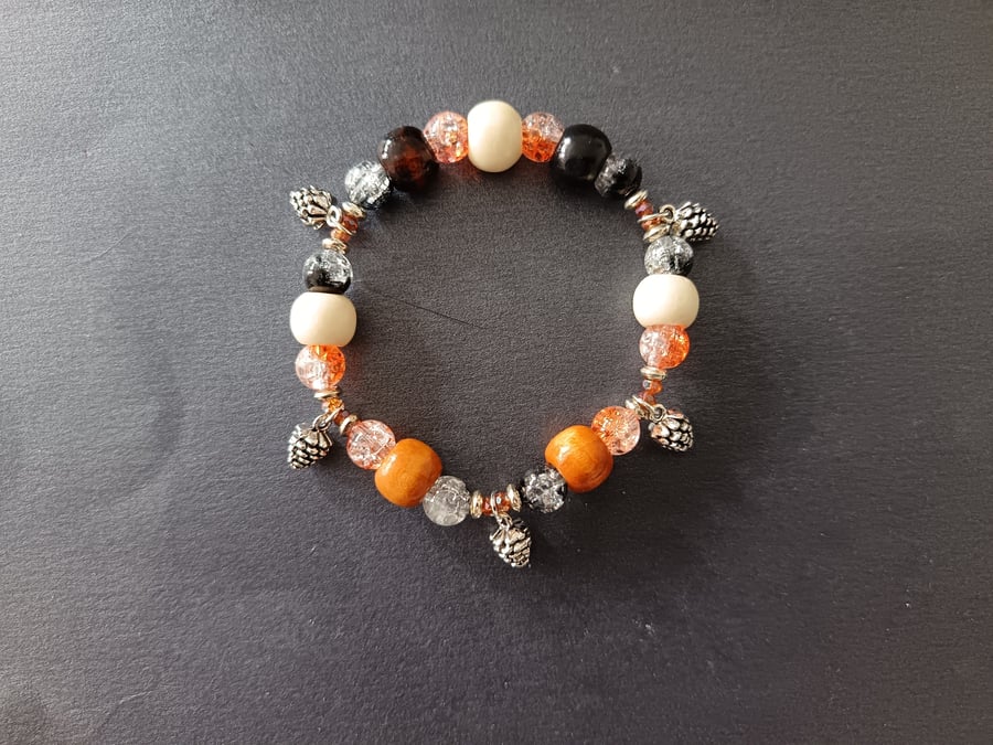 Elasticated beaded bracelet with earthy tones and pine cone charms 