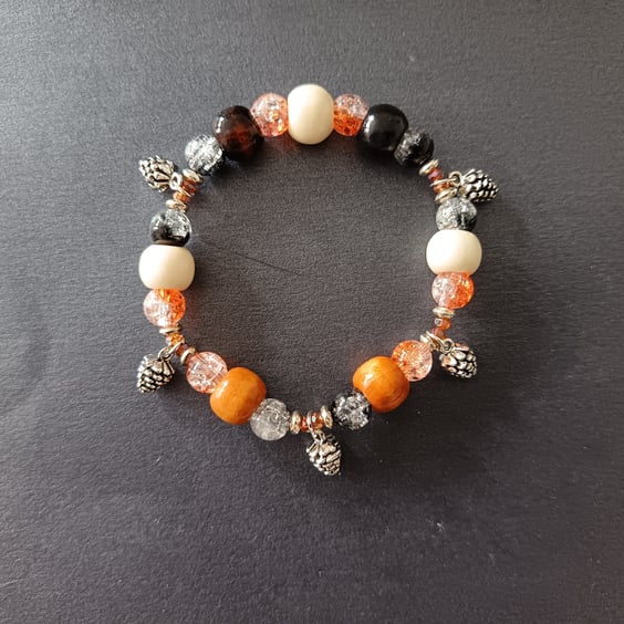 Elasticated beaded bracelet with earthy tones and pine cone charms 