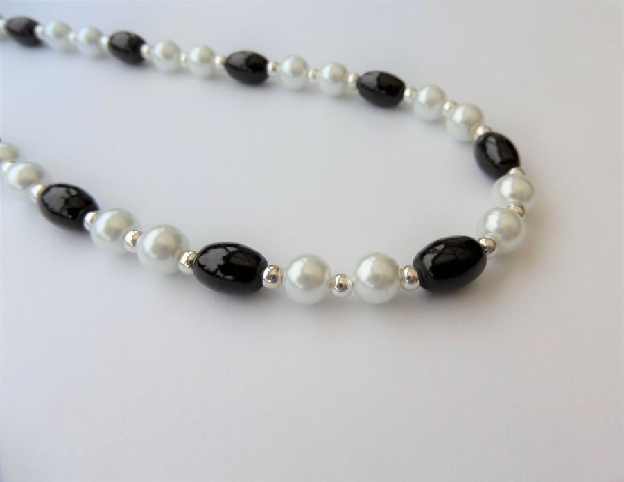 White glass pearl and oval black bead necklace.