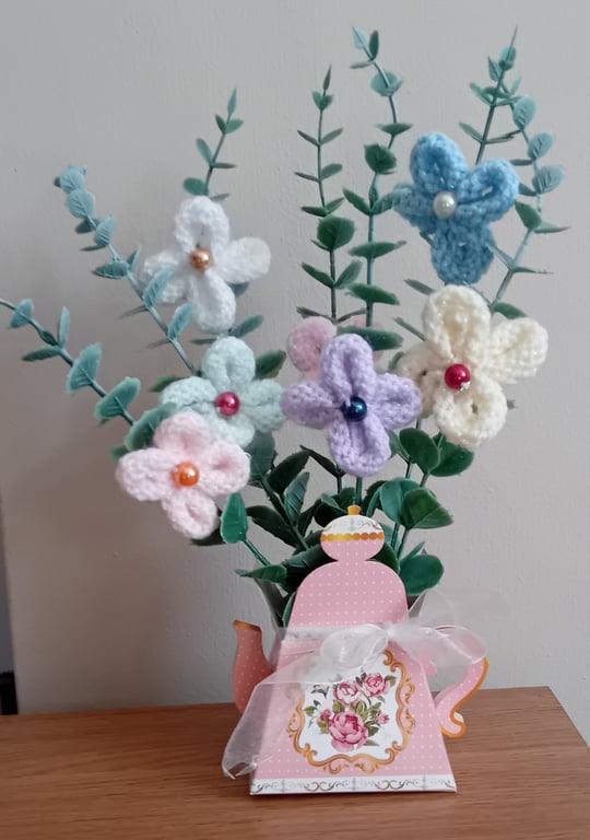Hand Knitted Flowers on artificial stems displayed in a lovely card teapot
