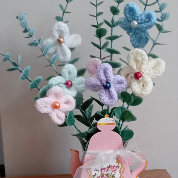 Hand Knitted Flowers on artificial stems displayed in a lovely card teapot