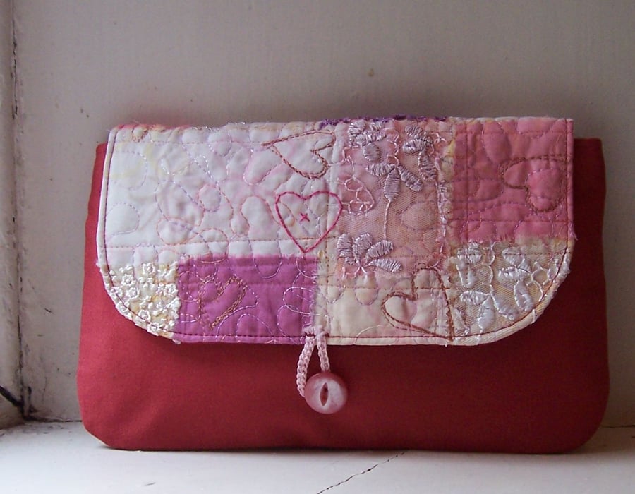 Soft fabric clutch bag with hand and machine embroidery in pink