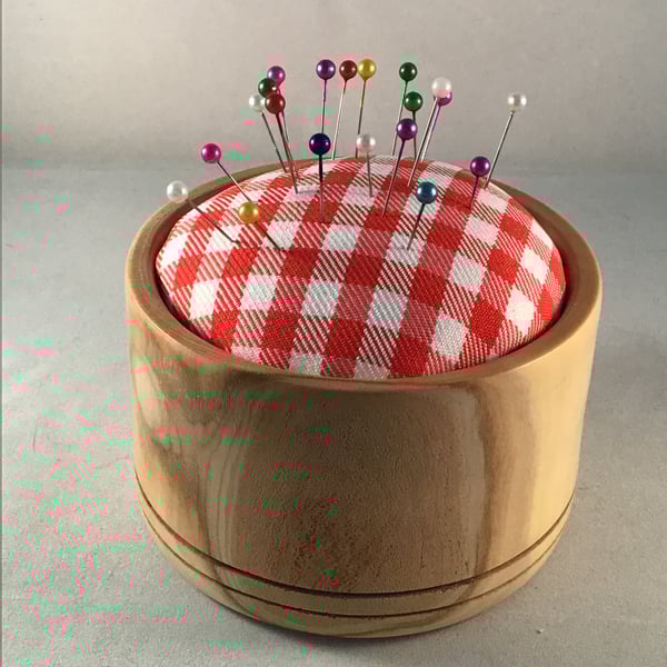 Natural wood pin cushion.