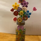 Button flower in a salt shaker vase