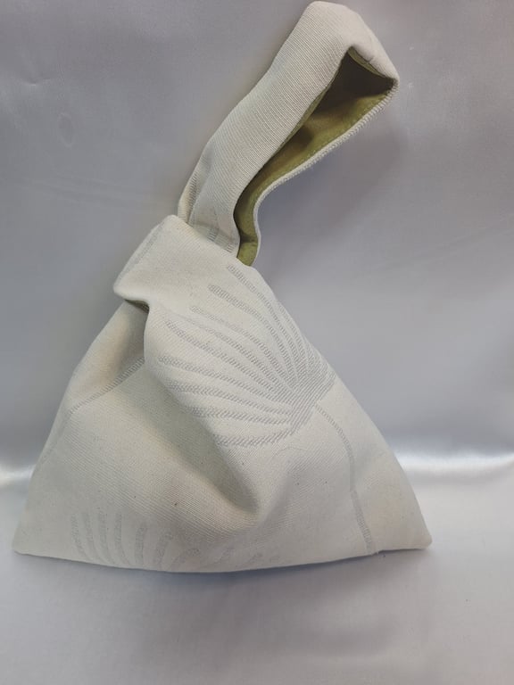 Beige fan palm botanical fabric Japanese knot bag with a green taffeta lining.