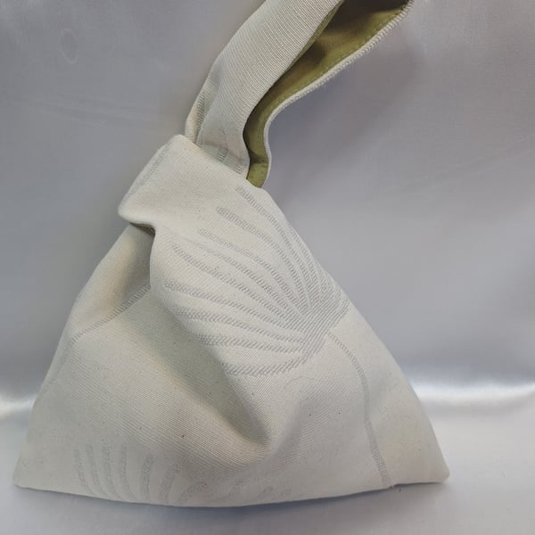 Beige fan palm botanical fabric Japanese knot bag with a green taffeta lining.