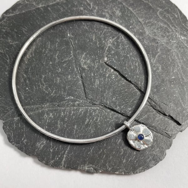 Sterling silver bangle with sapphire set flower charm