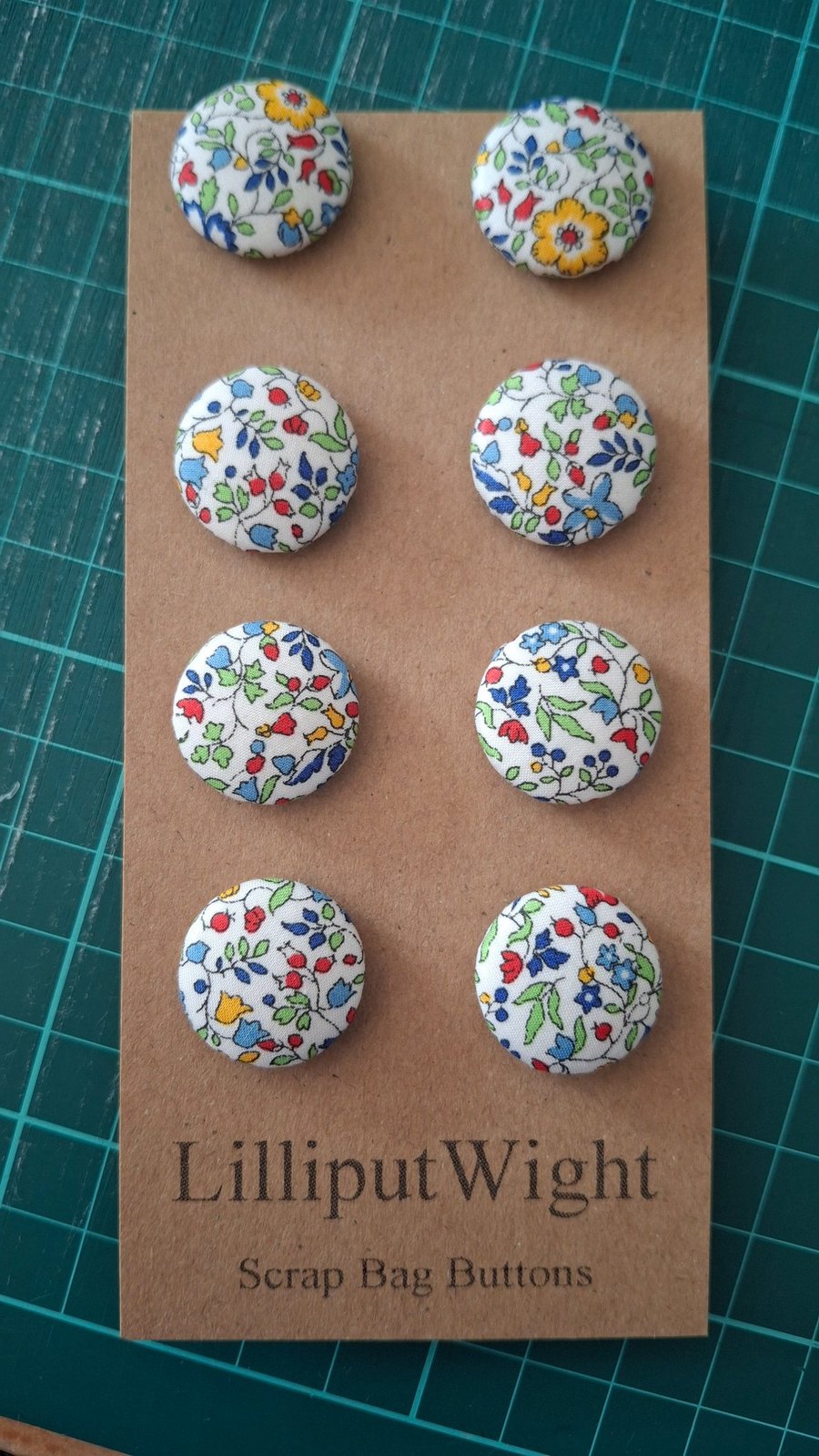Set of eight scrap bag buttons - floral design on off white background