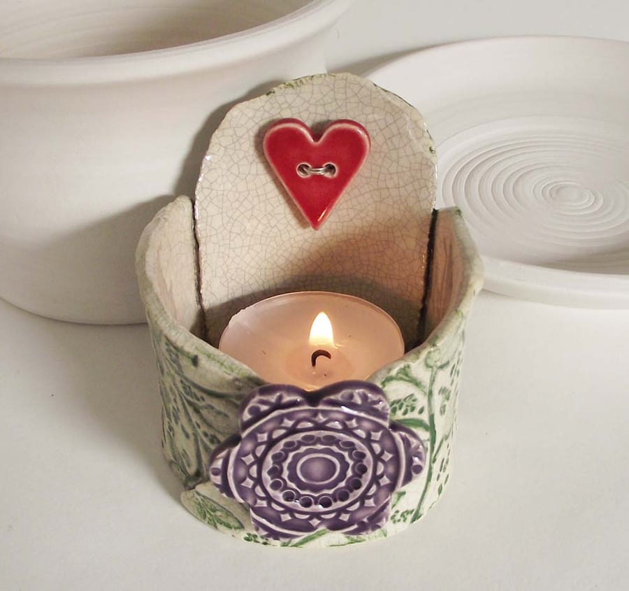Small ceramic tea light holder with heart and flower.