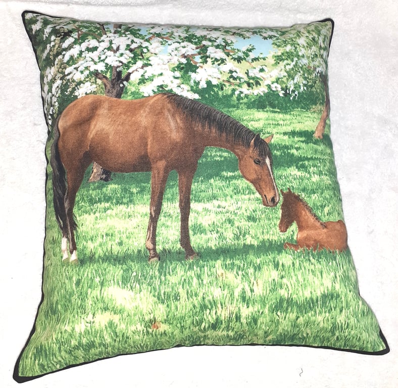 Mare and foal in a field under pretty flowering trees cushion