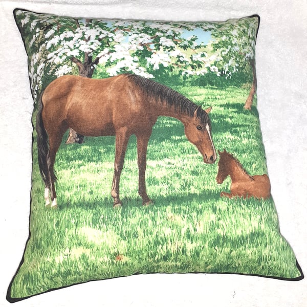 Mare and foal in a field under pretty flowering trees cushion