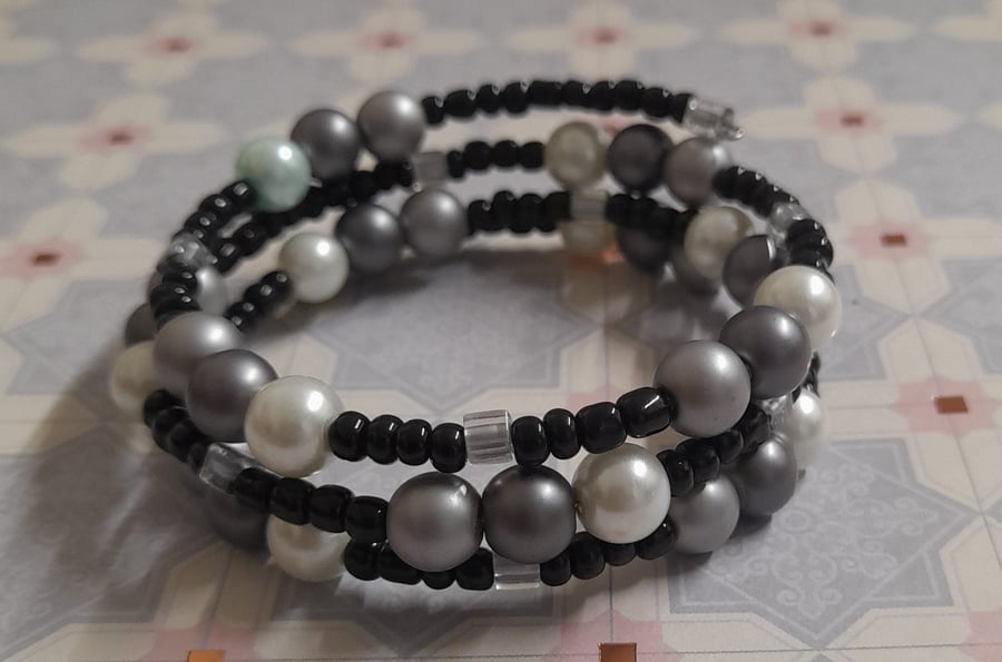 SHADES OF WHITE, GREY, SILVER AND BLACK MEMORY WIRE BRACELET.