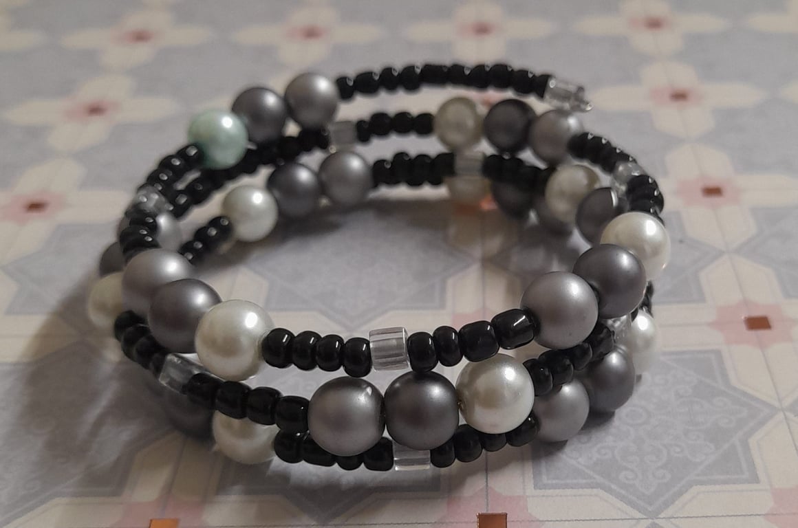 SHADES OF WHITE, GREY, SILVER AND BLACK MEMORY WIRE BRACELET.