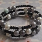 SHADES OF WHITE, GREY, SILVER AND BLACK MEMORY WIRE BRACELET.