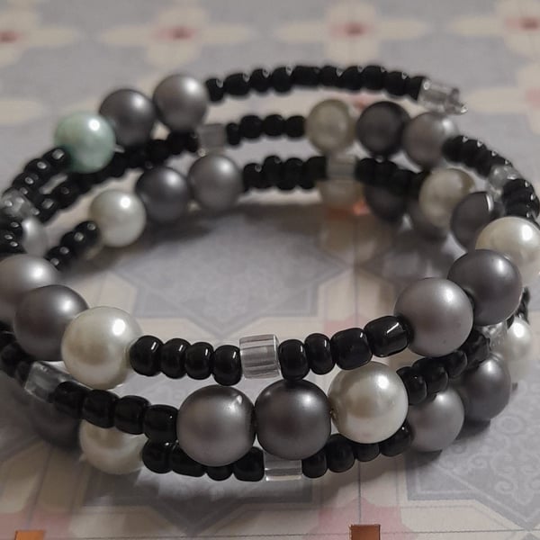 SHADES OF WHITE, GREY, SILVER AND BLACK MEMORY WIRE BRACELET.