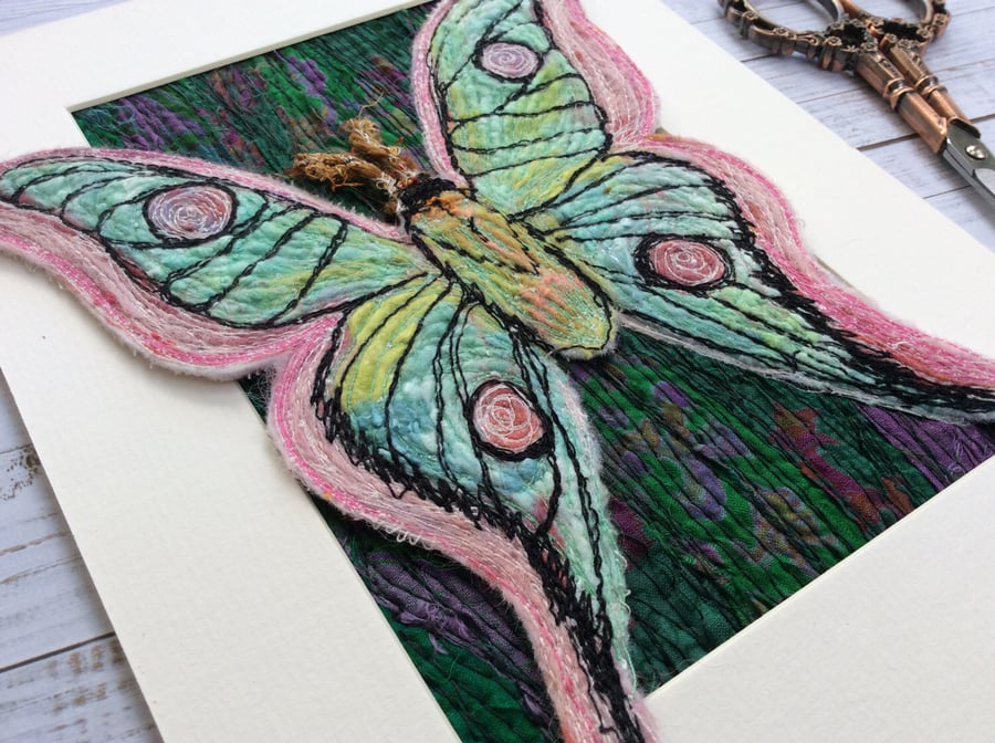 Needle felted butterfly with a recycled green background. 