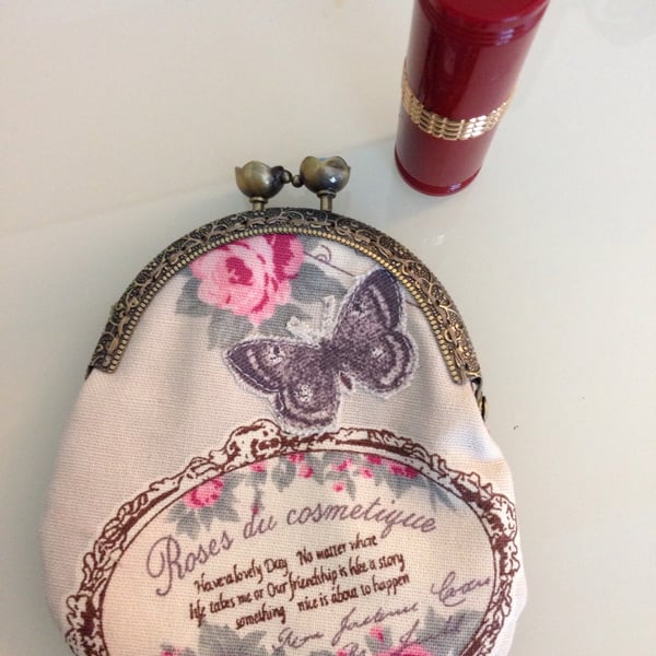 Vintage inspired purse featuring roses and an appliqued butterfly & brass frame