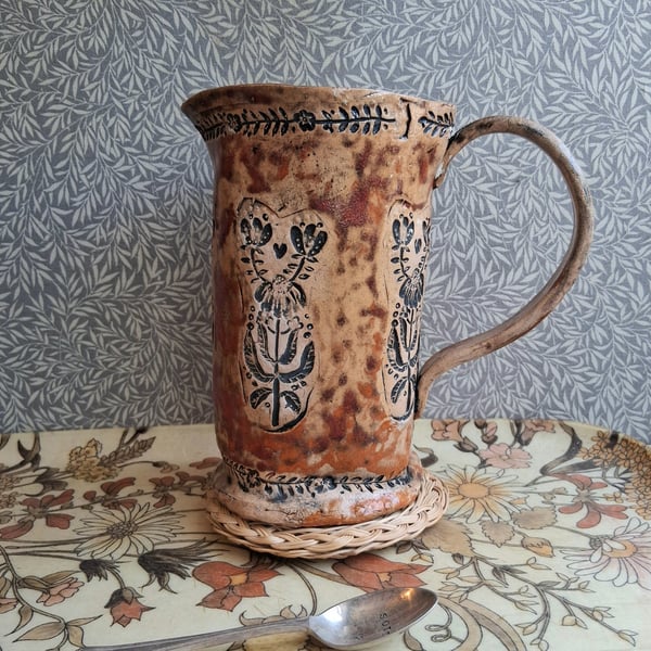 folk floral jug in burnt tomato and pumpkin, see photos for crack above handle