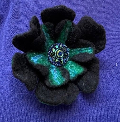Felted black flower brooch.