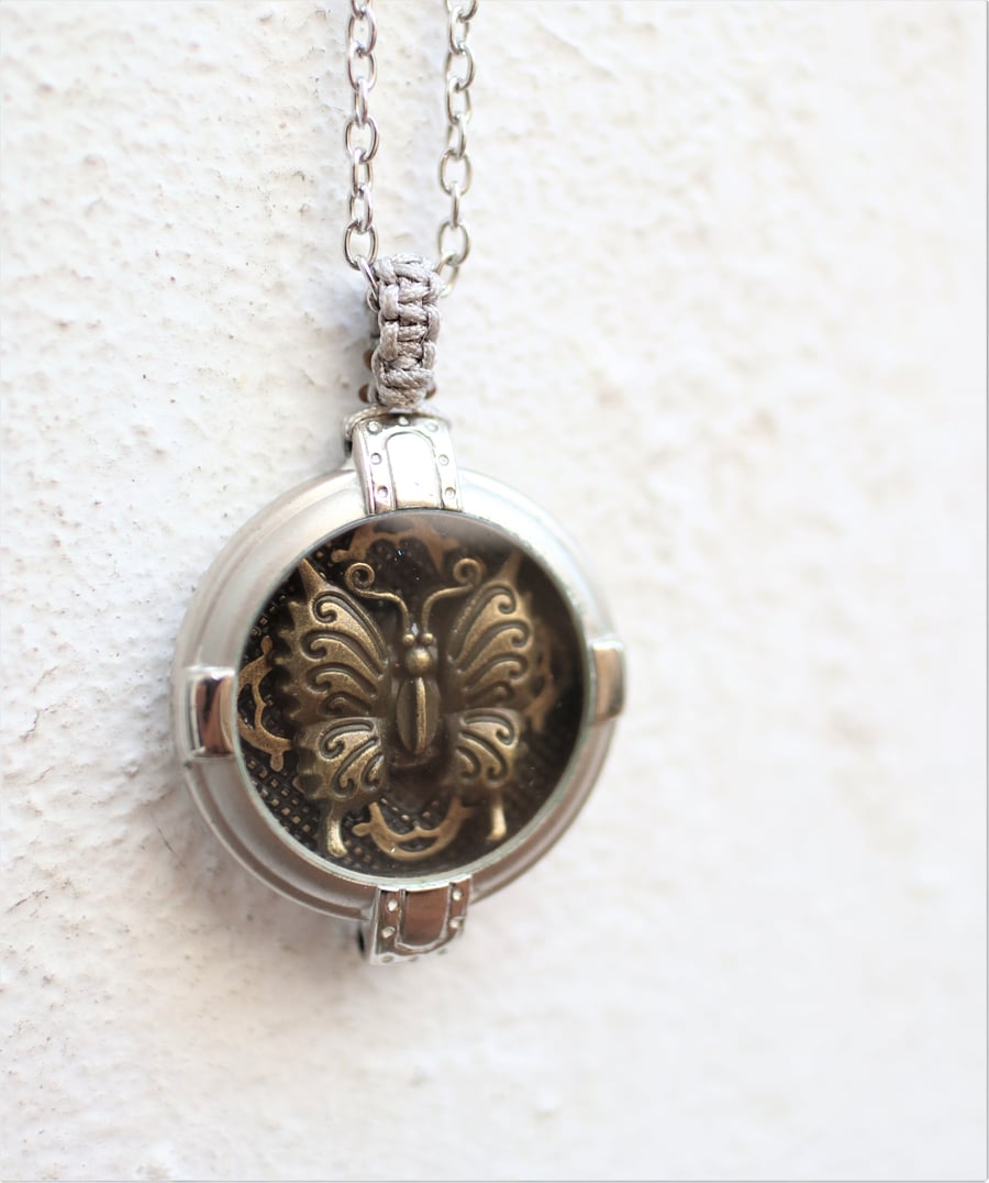 Upcycled watch case decorated with a vintage brass butterfly statement necklace