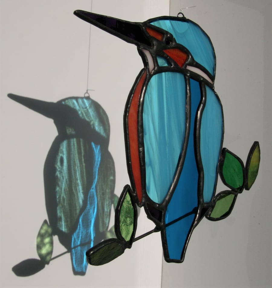 Handmade stained glass kingfisher bird on branch