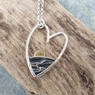 Silver heart shaped sun rising over the sea pendant