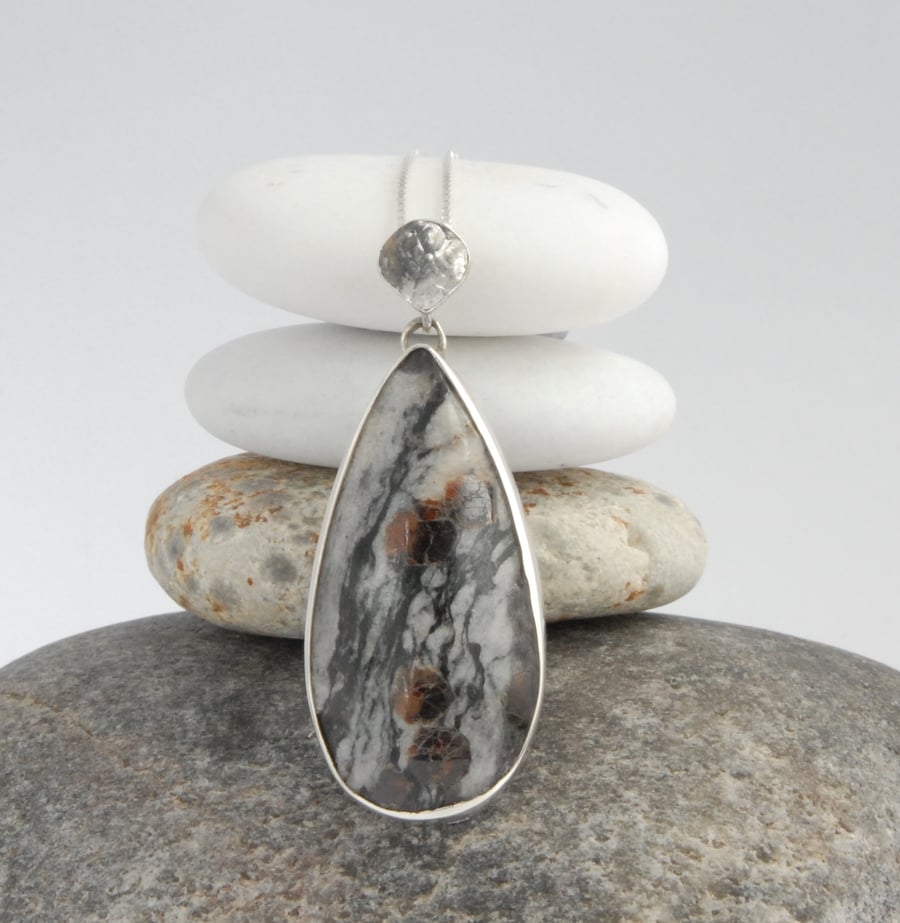 Sterling silver and garnet crystals in granite pendant.