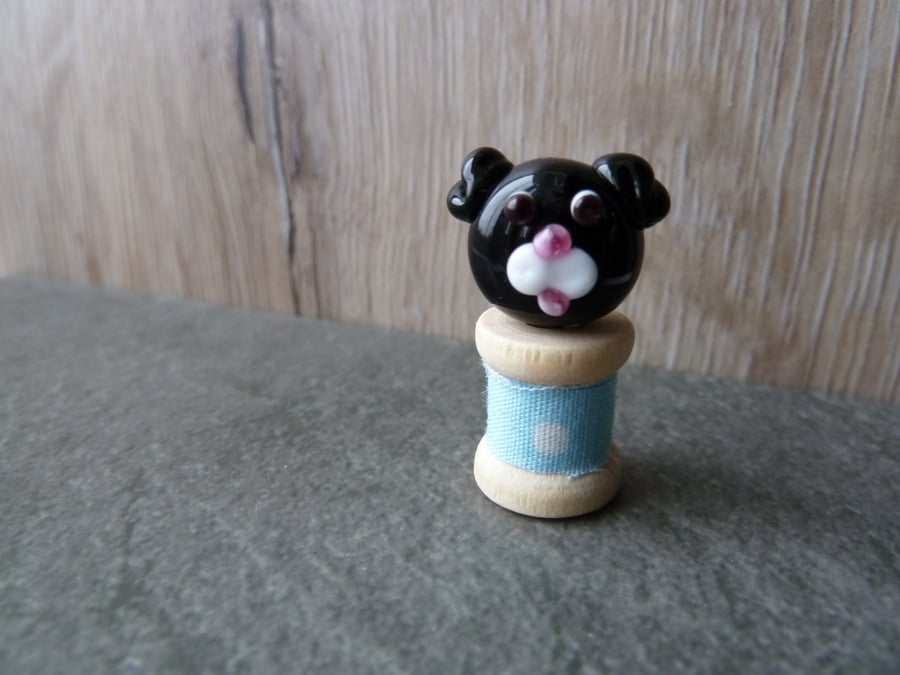 glass dog face on wooden bobbin 