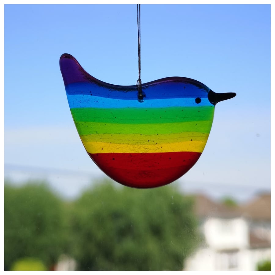 small 'Rainbow Wren of Hope' bird with a purple tipped tail and head 