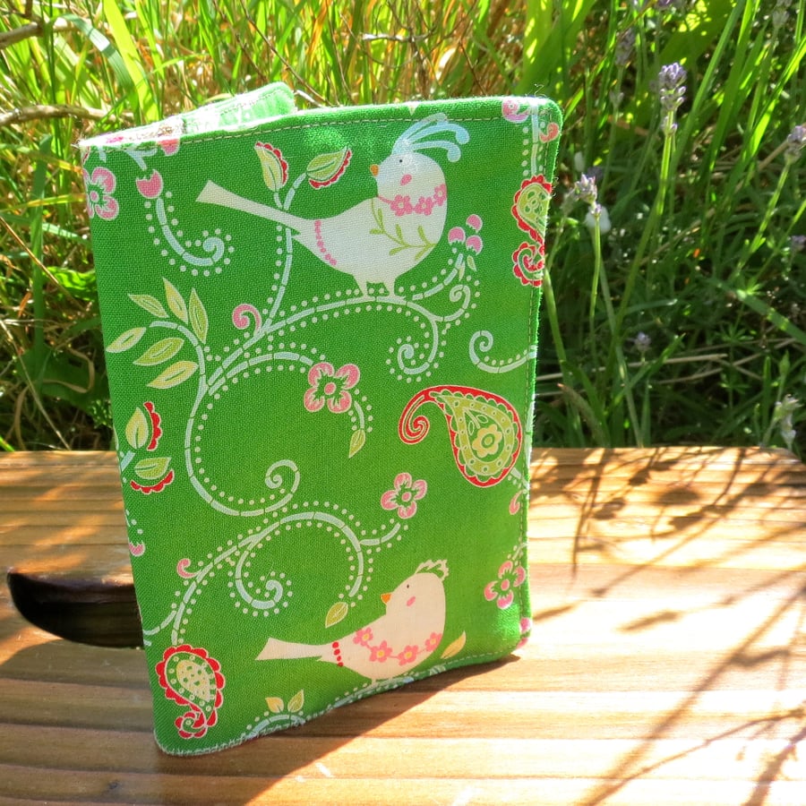 A fabric passport cover with a whimsical bird design.