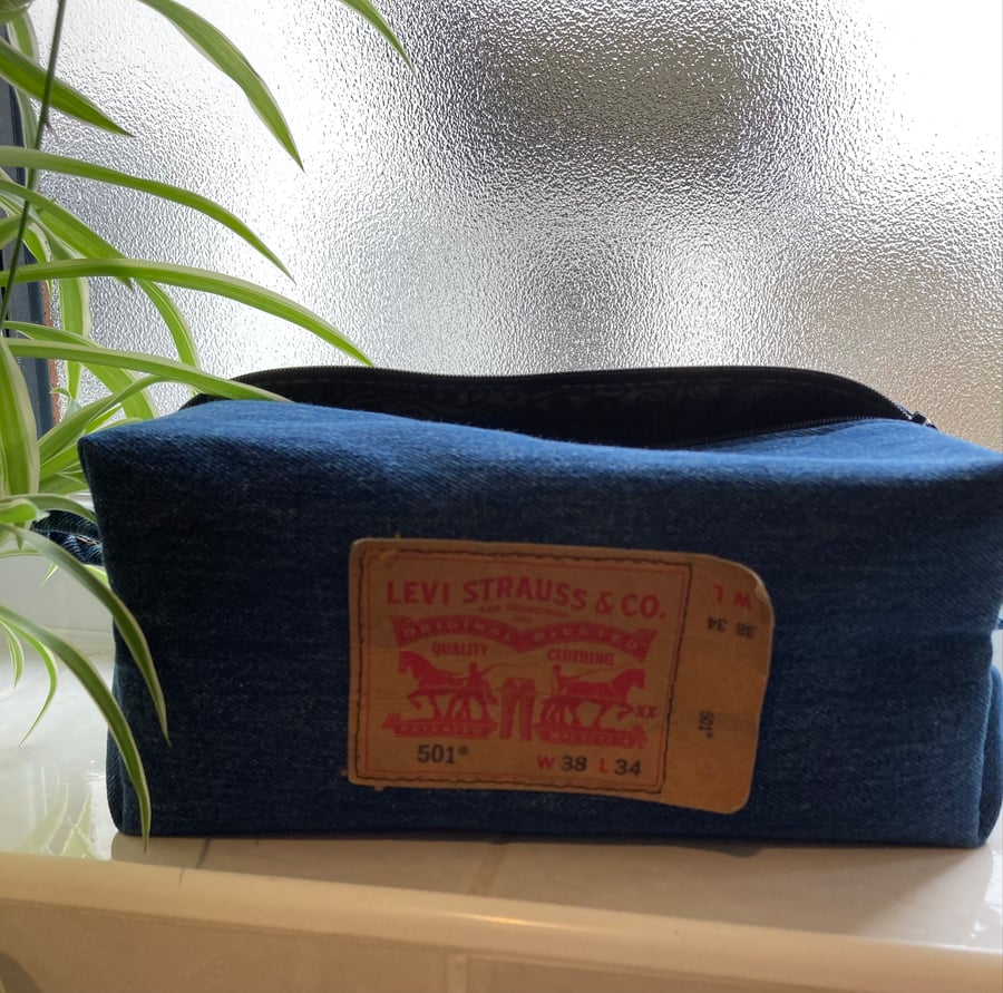 Blue denim wash bag. Boxy shape. Top zip fully opening. 