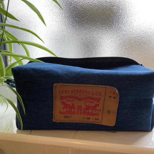 Blue denim wash bag. Boxy shape. Top zip fully opening. 