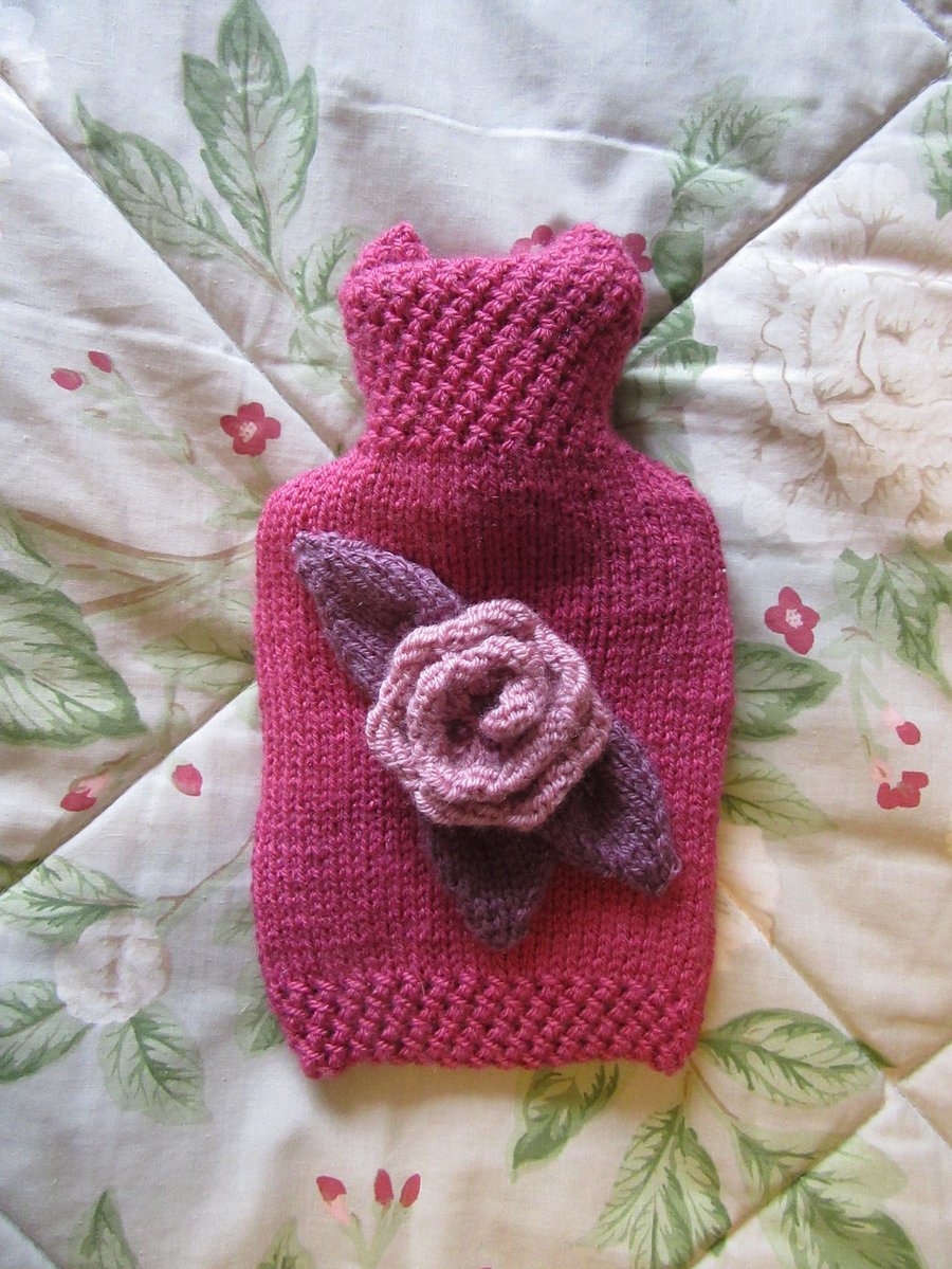 Hand knitted raspberry 'n' rose hot water bottle cover