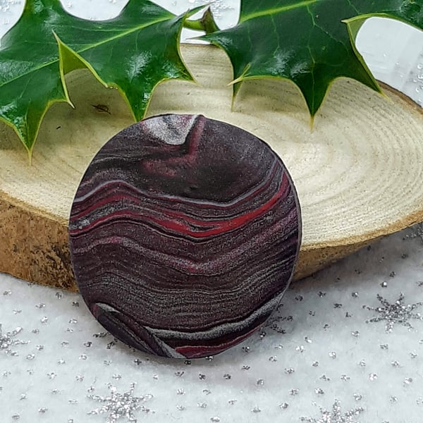 Red, black and silver circular brooch