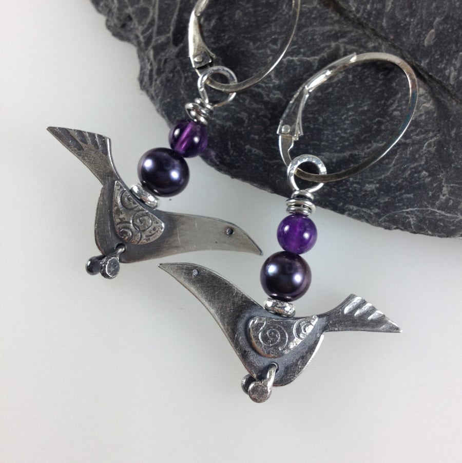 Silver bird earrings with amethyst and black pearl.