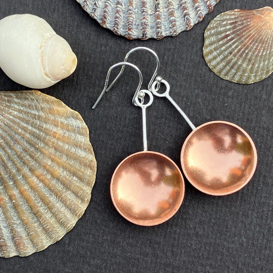 Sterling silver and copper spoon dangle earrings with hammered detail.