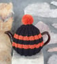 Small Tea Cosy for 2 Cup Tea Pot, Black & Orange, Hand Knitted, Wool Mix Yarn - Image 1